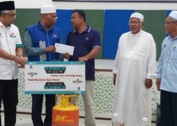 IDRIS Ahmad (dua dari kiri) menyampaikan sumbangan kepada salah seorang mangsa kepala air dan banjir ketika program Penyampaian Sumbangan Bantuan Banjir Skuad Musaadah Keluarga Malaysia di SMA Yayasan Khairiah, Kupang hari ini.