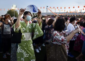 PENGUNJUNG mengenakan pakaian tradisional masyarakat Jepun, Kimono, sedang menari ketika menghadiri Festival Bon Odori yang berlangsung dekat Kompleks Sukan Stadium Panasonic di Shah Alam, Selangor, malam tadi. - UTUSAN / ZULFADHLI ZAKI