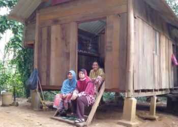 ITI Fatimah Junus ditemani ibunya, Aminah Hussain (kiri) berada di hadapan pondok milik ibu saudaranya, Uggu (duduk, belakang) di Kampung Paya Menora, Kuala Ketil di Baling.