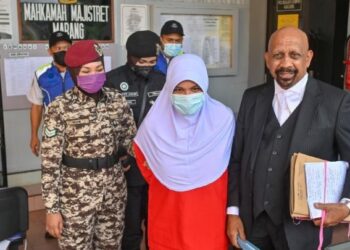 SUHAINI Mohd. (tengah) ditemani Naran Singh ketika dibawa keluar dari Mahkamah Majistret Marang, Terengganu, hari ini. - UTUSAN/PUQTRA HAIRRY ROSLI