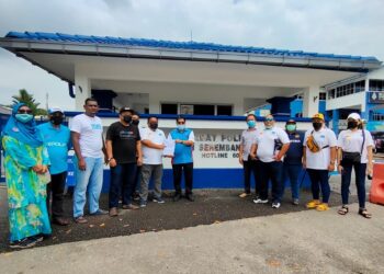 MOHAMAD Afif Anuar (enam dari kiri) bersama Romli menunjukkan salinan laporan polis yang dibuat mereka di IPD Seremban di Seremban 2, Seremban hari ini.