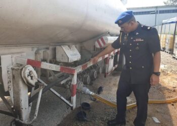 AHMAD Khuzairi Salamat menunjukkan lori tangki yang digunakan sindiket untuk memindahkan minyak diesel bersubsidi dalam serbuan di sebuah premis tidak bernombor di kawasan perindustrian Mahsan, Bahau, kelmarin.