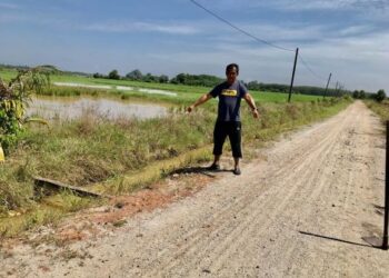 MOHD. Rasli Mat Yusof menunjukkan pembinaan tali air dan jalan di atas tanah milik penduduk di Kampung Padang Beliong, Pasir Mas, Kelantan, semalam. - UTUSAN/ROSLIZA MOHAMED