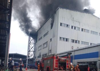 ANGGOTA bomba memadam kebakaran di tingkat tiga kilang memproses suplemen ayam di kawasan perindustrian Kertih, Kemaman. - UTUSAN/NIK NUR IZZATUL HAZWANI NIK ADNAN