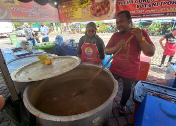 AZRIL Bidin dibantu Nurazwani Mohd. Ridzuan sedang memasak kuah laksa di MITC, Ayer Keroh, Melaka. - UTUSAN/AMRAN MULUP