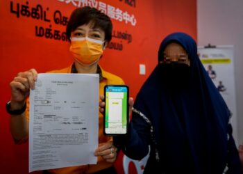 IKA (kanan) menunjukkan kumpulan sembang menggunakan nama tokoh pelabur saham popular yang disertainya manakala Nicole Tan Lee Koon menunjukkan laporan polis yang dibuat oleh Ika dalam sidang akhbar di Seremban hari ini. - UTUSAN/NAZARUDIN SHAHARI