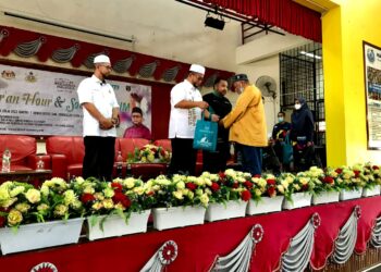 AHMAD Marzuk Shaary (tengah) menyampaikan bungkusan makanan kepada penerima di majlis Free Open  Market anjuran Yadim di Dewan SMK Pengkalan Chepa, Kota Bharu, Kelantan hari ini. - UTUSAN/ROSLIZA MOHAMED