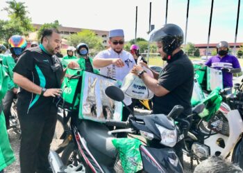 AHMAD Marzuk Shaary (tengah) meletakkan bungkusan makanan ke dalam bekas khas penghantar makanan untuk diserah kepada penerima yang tidak hadir pada Majlis Free Open Market anjuran Yadim di Dewan SMK Pengkalan Chepa, Kota Bharu, Kelantan. - UTUSAN/ROSLIZA MOHAMED