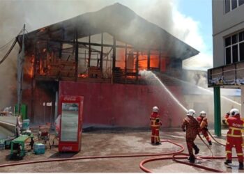 ANGGOTA bomba memadamkan kebakaran tujuh buah kedai di Jalan Dato' Mohd. Ali, Mersing.