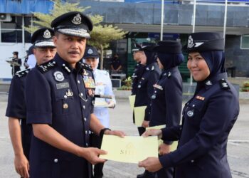 MOHD. Yusri Hassan (kiri) menyampaikan sijil penghargaan kepada anggota cemerlang di perhimpunan bulanan polis Kontinjen Pahang di Kuantan, Pahang. - UTUSAN/ DIANA SURYA ABD WAHAB