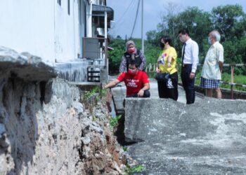 KERK Chee Yee (kiri) bersama penduduk melihat keadaan jalan retak serta berlakunya pemendapan di kawasan perumahan Taman Ayer Keroh Permai, Ayer Keroh, Melaka. - UTUSAN/RASUL AZLI SAMAD