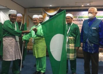 TUAN Ibrahim Tuan Man (tiga dari kanan) menyerahkan panji-panji kepada wakil jentera pilihan raya selepas merasmikan Mesyuarat Agung Tahunan Pas Kawasan Pasir Puteh di Sweet Beach Resort, Bachok, Kelantan hari ini / FOTO : ROSMIZAN RESDI