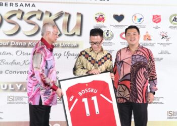 NAJIB TUn Razak (kiri) menyerahkan jersi Manchester United 'Bossku' kepada Vermillion Ng (tengah) yang memenangi bidaan pada Majlis Makan Malam Amal Bersama Bossku di Ipoh semalam. - UTUSAN/MUHAMAD NAZREEN SYAH MUSTHAFA