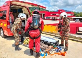 ANGGOTA Jabatan Bomba dan Penyelamat Malaysia sedang mengangkat mangsa, Nadia Azmi ke atas ambulans sejurus helikopter mendarat berdekatan Balai Bomba Gua Musang di Kelantan. -IHSAN JBPM
