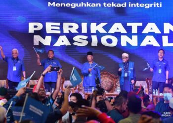 MUHYIDDIN Yassin (tengah) bersama Abdul Hadi Awang pada majlis pelancaran PN Peringkat Negeri Terengganu di Rusila, Marang malam semalam. - UTUSAN/PUQTRA HAIRRY ROSLI