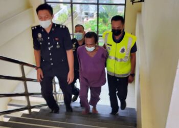 TERTUDUH (tengah) dibawa keluar dari mahkamah selepas didakwa di Mahkamah Sesyen di Raub, Pahang.