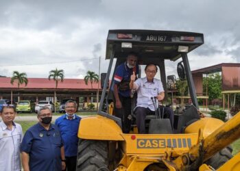 MAH Hang Soon menaiki jengkaut sebagai simbolik majlis pecah tanah pembinaan Dewan Terbuka SMK Slim dekat Tanjung Malim hari ini. - UTUSAN/MOHAMAD HAFIZI MOHD SAID.