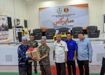 SAARANI Mohamad (dua dari kiri) menyampaikan kotak makanan kepada bekas tentera pada Program Saarani Bersama Bekas Askar Dewan Merdeka, Tapah hari ini. - UTUSAN/MOHAMAD HAFIZI MOHD SAID