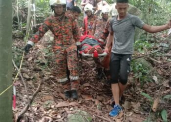 ANGGOTA Bomba berusaha membawa turun mangsa yang pengsan semasa mendaki di Bukit Gunung, Bachok, Kelantan hari ini. -IHSAN BOMBA BACHOK