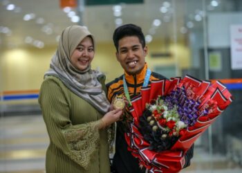 MUHAMAD Aznil Bidin bersama isterinya, Aina Izzati Masri ketika ditemui semasa dalam perjalanan pulang ke kampung halaman di Kampung Baru, Bukit Pinang di Kepala Batas. -UTUSAN/SHAHIR NOORDIN