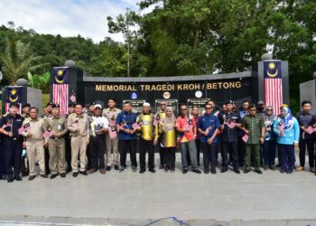 SAFUAN Salleh (tengah) menyerahkan Jalur Gemilang kepada peserta pada Majlis Konvoi Kembara Keluarga Malaysia sempena Pelancaran Bulan Kebangsaan dan Kibaran Jalur Gemilang negeri Perak di Memorial Tragedi Betong Kroh, Pengkalan Hulu dekat Gerik semalam. - UTUSAN/NORLIA RAMLI