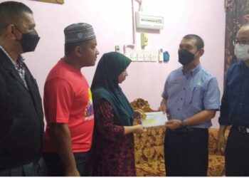 NOR Asmah Ismail (tengah) menerima bayaran faedah Perkeso daripada Mohamad Haron Othman (dua kanan) ketika berkunjung ke rumah mangsa di Sungai Petani, hari ini.