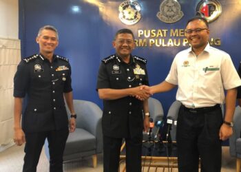 ISHAM Ishak bersalaman dengan Mat Kasim Karim sambil diperhatikan Mohd. Shuhaily Mohd. Zain (kiri) dalam sidang akhbar mengenai isu mat rempit di Ibu pejabat Polis Kontinjen (IPK) Pulau Pinang di George Town hari ini. - UTUSAN/IQBAL HAMDAN