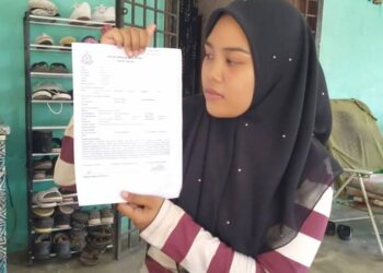 FITRI Nadia Bakar menunjukkan laporan polis yang dibuatnya selepas rantai dan cincin emas miliknya dilarikan seorang wanita dalam kejadian di rumahnya di Kampung Keda, Sungai Udang, Yan di sini. -UTUSAN/OTHMAN YAHAYA