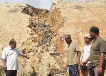 SHAMSUL ISKANDAR Mohd. Akin (kiri) bersama penduduk meninjau keadaan rekahan serta hakisan tanah di kawasan projek perumahan yang merbahayakan penduduk Kampung Seberang Anak Air, Ayer Molek, Melaka. - UTUSAN/RASUL AZLI SAMAD
