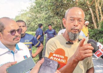 SHAMSUL Iskandar Mohd. Akin (kiri) bersama penduduk meninjau keadaan rekahan serta hakisan tanah di kawasan projek perumahan yang membahayakan penduduk Kampung Seberang Anak Air, Ayer Molek, Melaka. – UTUSAN/RASUL AZLI SAMAD