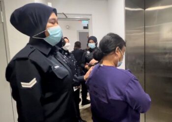 PEMBANTU rumah yang disyaki mendera dua anak majikannya dibawa keluar dari Mahkamah Majistret, Kuala Terengganu, hari ini. - UTUSAN/TENGKU DANISH BAHRI TENGKU YUSOFF