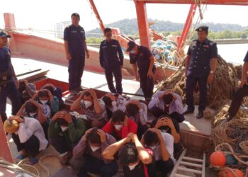 WAN Muhammad Aznan Abdullah (berdiri, tengah) memeriksa nelayan warga Vietnam yang ditahan di Kemaman, hari ini. - UTUSAN/ NIK NUR IZZATUL HAZWANI NIK ADNAN