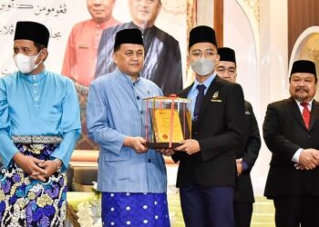 MOHD. Arifin Mohd Arif (dua kiri) menyampaikan sijil penghargaan kepada salah seorang pelajar cemerlang peperiksaan SMU di Kota Kinabalu hari ini.
