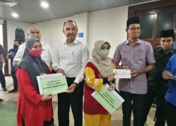 MOHD. JAFNI MD. SHUKOR dan Mohd. Fared menyampaikan sumbangan kepada mangsa ribut Flat Ros Merah, Taman Johor Jaya.