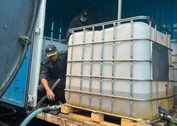 ANGGOTA penguat kuasa KPDNHEP Pulau Pinang memeriksa minyak diesel bersubsidi yang dirampas daripada sebuah lori dalam satu serbuan di stesen minyak di Nibong Tebal, Pulau Pinang semalam.