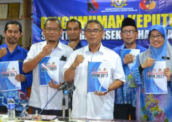 MD. Fiah Md Jamin (tiga dari kanan) menunjukkan laporan keputusan STPM Negeri Sembilan dalam sidang akhbar di Nilai, Seremban hari ini. - UTUSAN/ZAKKINA WATI AHMAD TARMIZI