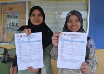 MASYITAH Mat Bukri (kanan) dan Nur Hani Hasya menunjukkan keputusan cemerlang STPM yang diperoleh mereka ketika ditemui di SMAP Labu, Seremban, hari ini. - UTUSAN/ZAKKINA WATI AHMAD TARMIZI