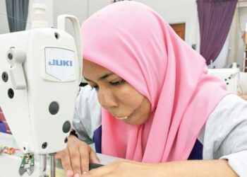 SITI Zulaikha Abdul Muin tekun menjahit beg duit syiling di bengkel Koperasi Komuniti Cakna Wakaf Tapai Marang Berhad, Marang, Terengganu. – mingguan/KAMALIZA KAMARUDDIN
