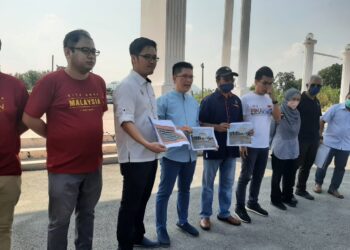 WONG Kah Woh (tiga dari kiri) menunjukkan pelan pembangunan menaiktaraf infrastruktur di Taman Pinggir Sungai Pinji di Ipoh hari ini. - UTUSAN/SAYED HESHAM IDRIS