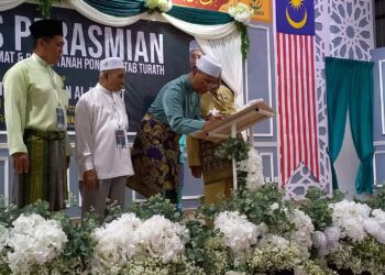 IDRIS Ahmad menandatangani plak perasmian Dewan Besar dan Upacara Pecah Tanah Pondok Kitab Turath di Kompleks Pendidikan Al-Rahmat di Solok Gaong, Bukit Lintang, Melaka. - UTUSAN/AMRAN MULUP