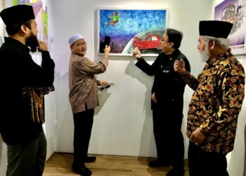 MD. Anizam Abdul Rahman (dua dari kiri) sambil diperhatikan Khairil  Anwar Abu Kassim  (dua dari kanan) melihat pameran di Balai Seni Lukis Kelantan, Kota Bharu, Kelantan hari ini.-UTUSAN/ROSLIZA MOHAMED