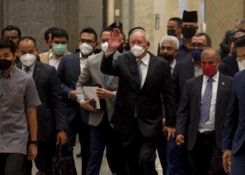 NAJIB Tun Razak melambai tangan kepada penyokongnya di Istana Kehakiman, Putrajaya hari ini. -UTUSAN/FAISOL MUSTAFA