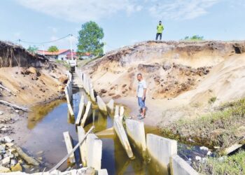 AHMAD MUZAFAR Jusoh melihat longkang yang rosak ekoran tanah runtuh dan hakisan 
di Perumahan Makmur Hijrah Jaya di Kuantan, Pahang. – UTUSAN/SHAIKH AHMAD RAZIF