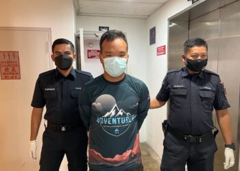 MUHAMMAD Asri Abdullah (tengah) yang dituduh mencuri duit tabung surau dibawa keluar dari Mahkamah Majistret Kuala Terengganu hari ini. - UTUSAN/TENGKU DANISH BAHRI TENGKU YUSOFF