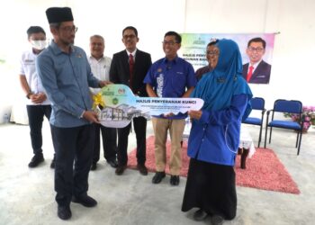 PENGARAH Jabatan Hal Ehwal Agama Islam Negeri Sembilan, Datuk Mohd. Zaidi Ramli menyerahkan replika kunci kepada Maimun sambil diperhatikan oleh Mohamad (tiga dari kanan) pada Majlis Penyerahan Kunci Bangunan Baharu SMA Chuah di Port Dickson hari ini.-UTUSAN/BADRUL HAFIZAN MAT ISA.