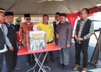 TUAN Ibrahim Tuan (dua dari kanan) melihat jemputan mengisi tabung untuk kutipan pembinaan Maahad Tahfiz, sebagai gimik perasmian di Pasir Tumboh  Kota Bharu,Kelantan hari ini.-UTUSAN/ROHANA MOHD.NAWI