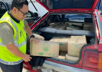 PENGUATKUASA KPDNHEP sedang memeriksa minyak masak paket bersubsidi yang dirampas di hadapan Sekolah Menengah Kebangsaan (SMK) Kedai Mulong, Kota Bharu, Kelantan pagi tadi.UTUSAN/IHSAN KPDNHEP