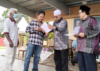AHMAD Yakob (dua dari kanan) menyerahkan geran tanah kepada penerima pada program Menteri Besar Jjupo Mato Dengan Rakyat di Bandar Baru Pasir Mas, Kelantan hari ini.-UTUSAN/ROHANA ISMAIL