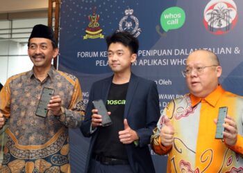 MOHD. Zawawi Ahmad Mughni (kiri) menunjukkan aplikasi Whoscall selepas melancarkannya di Foyer Bangunan Sultan Salahuddin Abdul Aziz Shah di Shah Alam, Selangor, hari ini