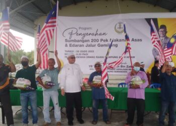 RAZMAN Zakaria (tengah) bersama sebahagian penerima sumbangan pek makanan asas pada program edaran Jalur Gemilang di Bagan Serai hari ini. - UTUSAN/WAT KAMAL ABAS